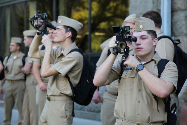 People in uniform looking through technology