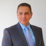 Man with short dark hair looking at the camera