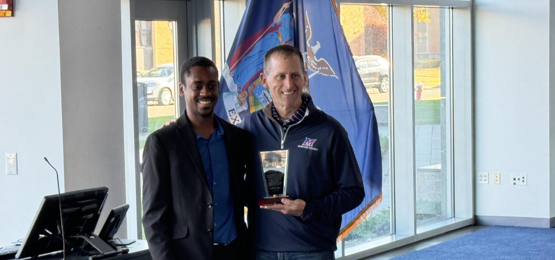 Two men taking a photo with the National Society of Black Engineers award Two men taking a photo with the National Society of Black Engineers award