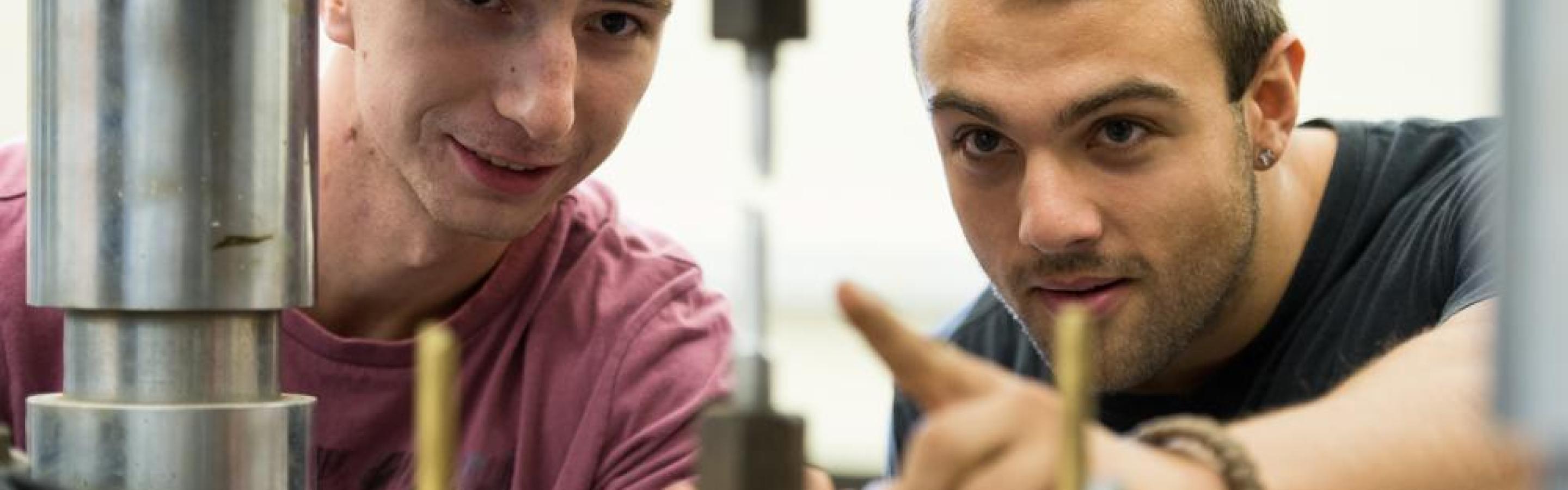 Two men inspecting a tool